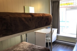 Chambre climatisée avec lit superposé et salle de bain partagée