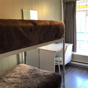 Chambre climatisée avec lit superposé et salle de bain partagée